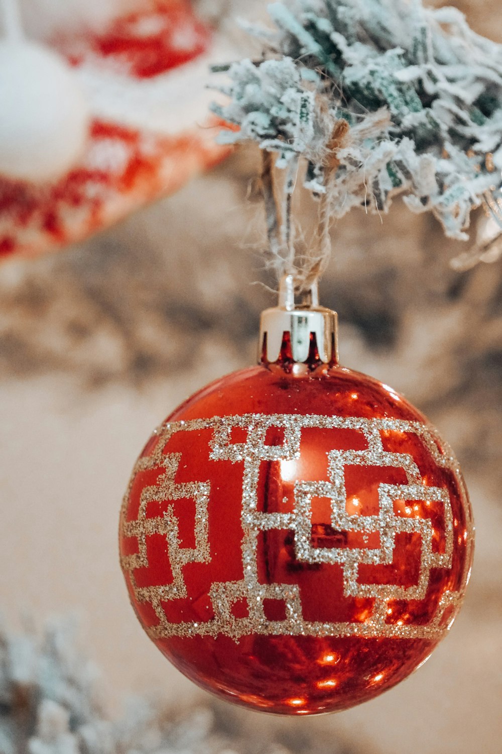 a red ornament hanging from a christmas tree