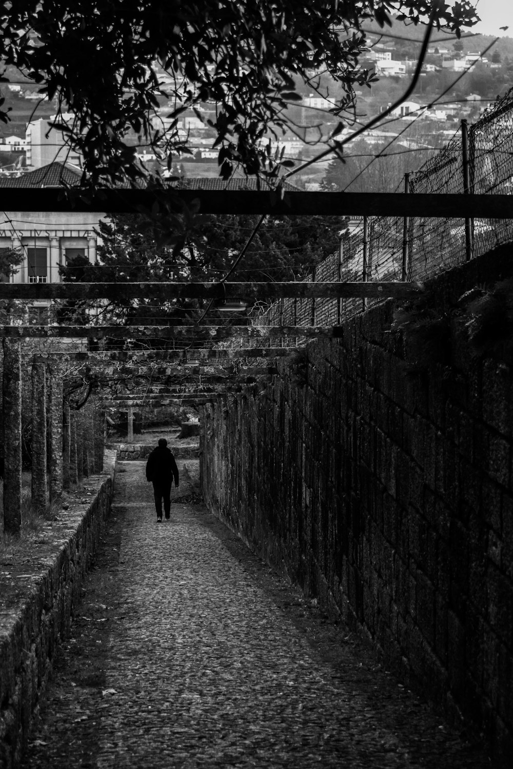 a black and white photo of a person walking down a street