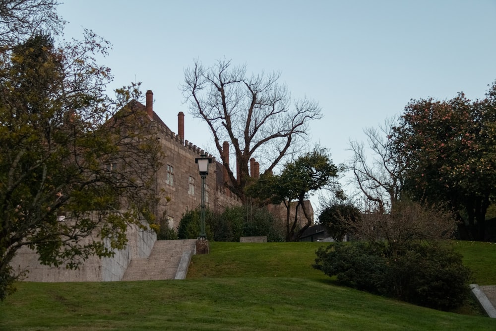 a large brick building sitting on top of a lush green field