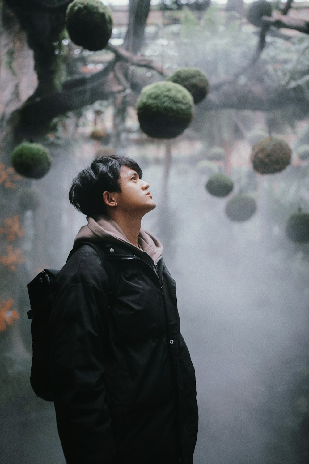 a woman standing in front of a tree filled with balls