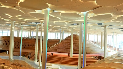 A spacious auditorium filled with natural light and modern seating arrangements.