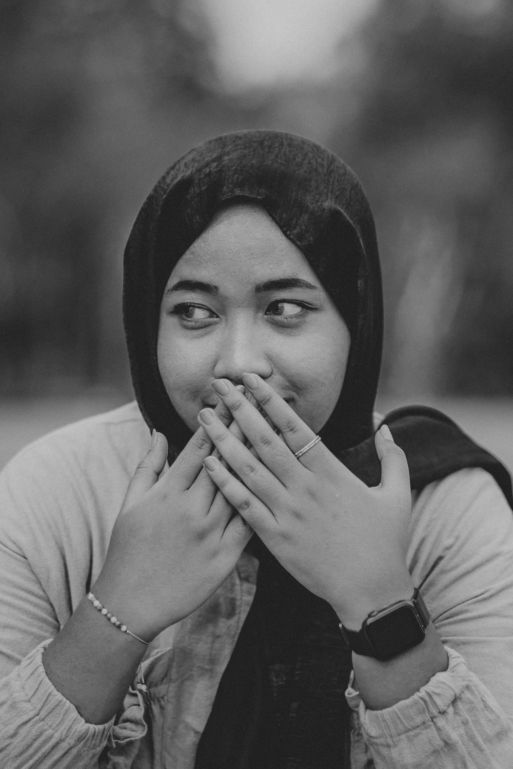 a woman covers her mouth with her hands