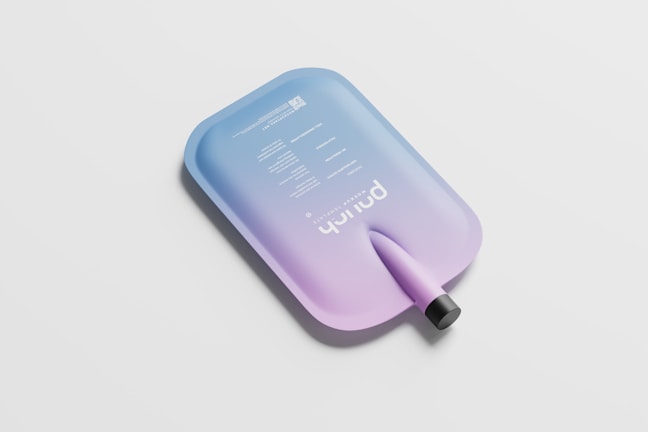 A sleek, modern water pouch features a gradient color scheme from blue to purple with white text labeling its specifications and brand name. The design is minimalist with a clean surface and a black spout.