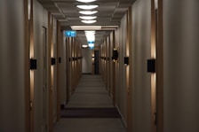 Hallway view showing entrance doors to hotel rooms with soft lighting.