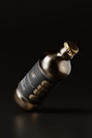 a bottle of wine with a gold cap on a black background