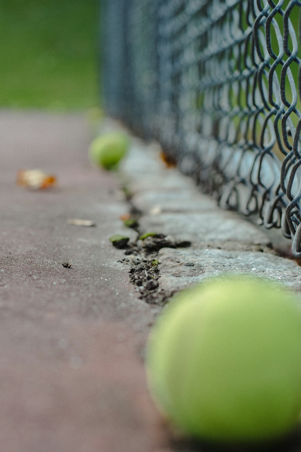 a tennis ball sitting on the ground next to a net