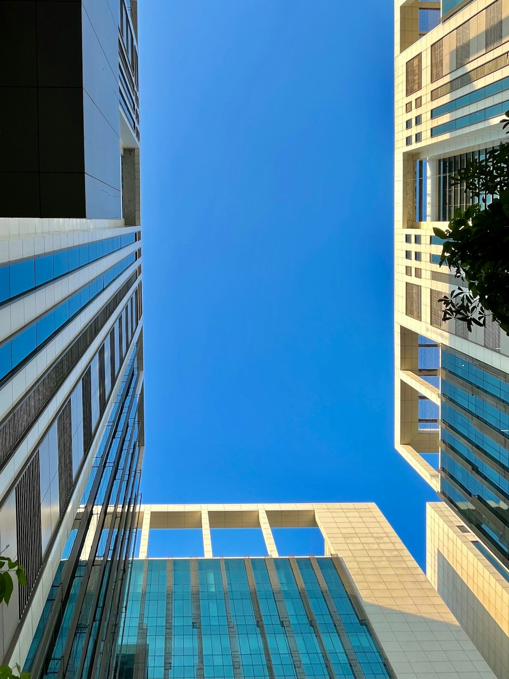 a group of tall buildings with a blue sky in the background