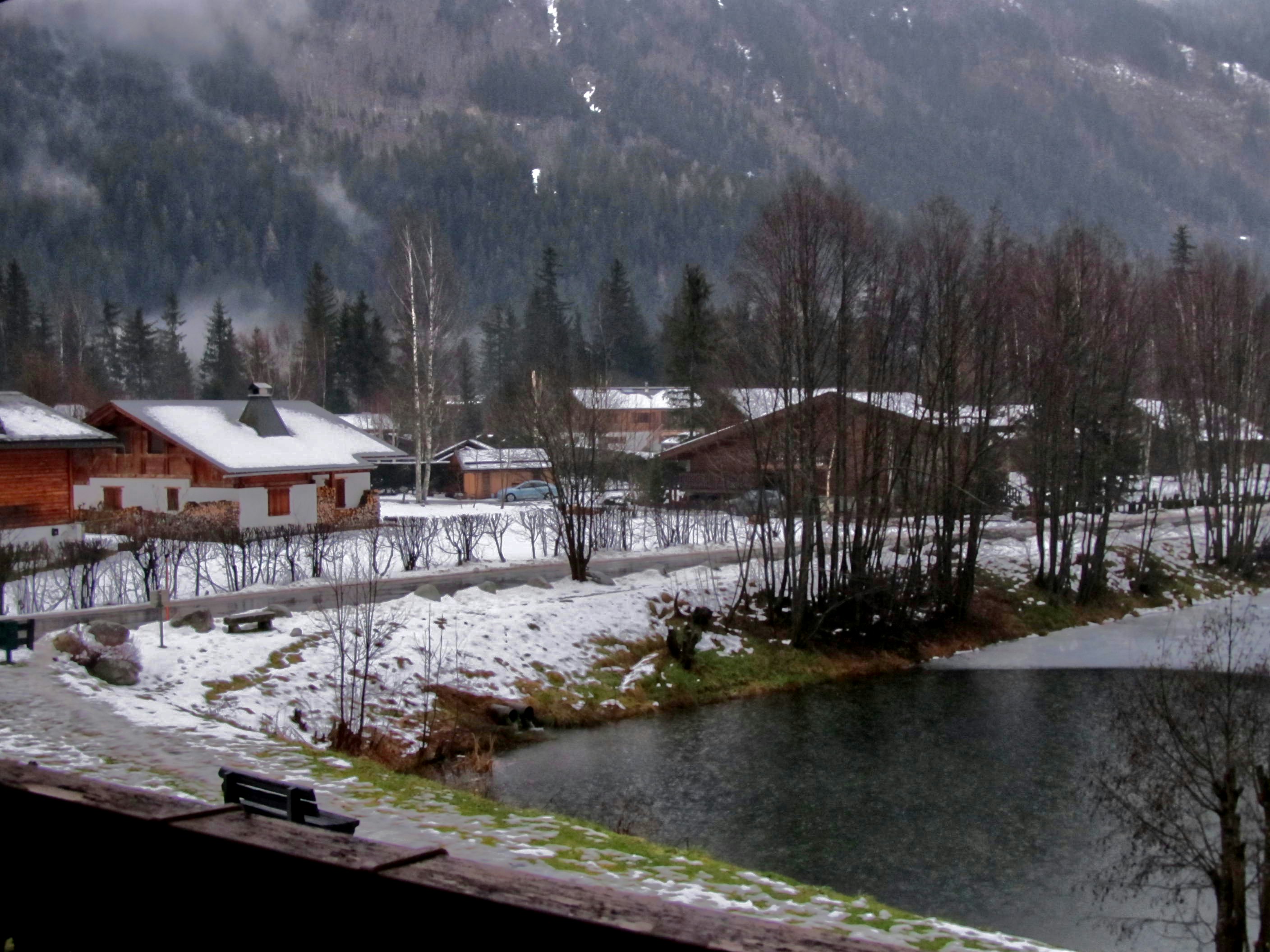 a snowy landscape with a lake and a mountain in the background