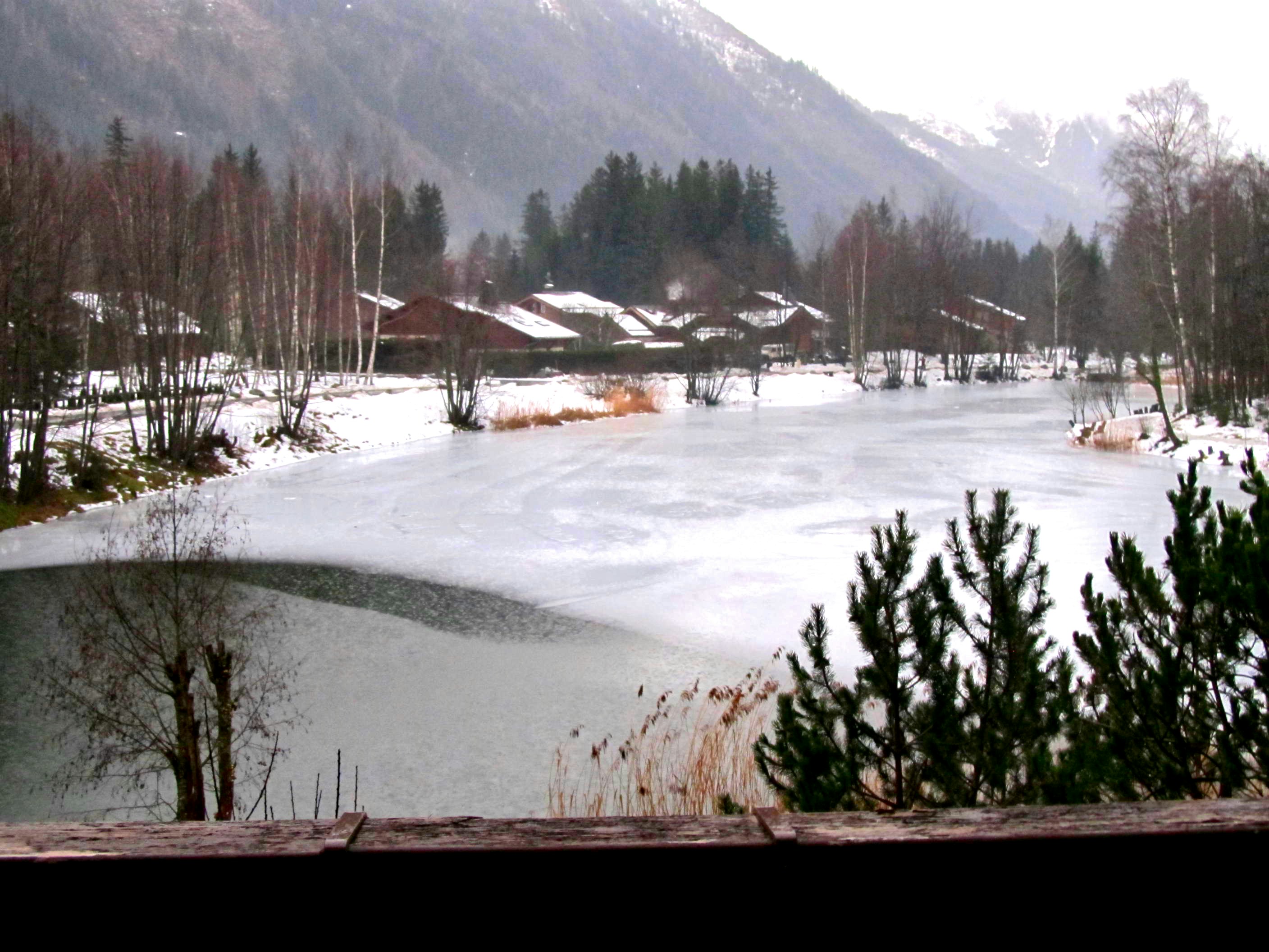 a lake surrounded by snow covered mountains and trees