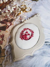 Close-up of an elegant embroidered wedding hoop with floral patterns and names stitched in soft colors.