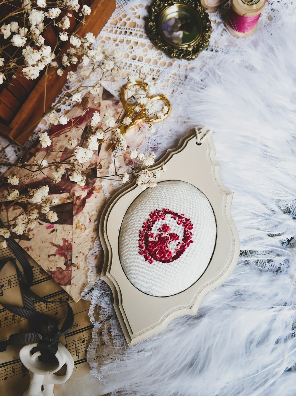 a white table topped with a cross stitch wreath