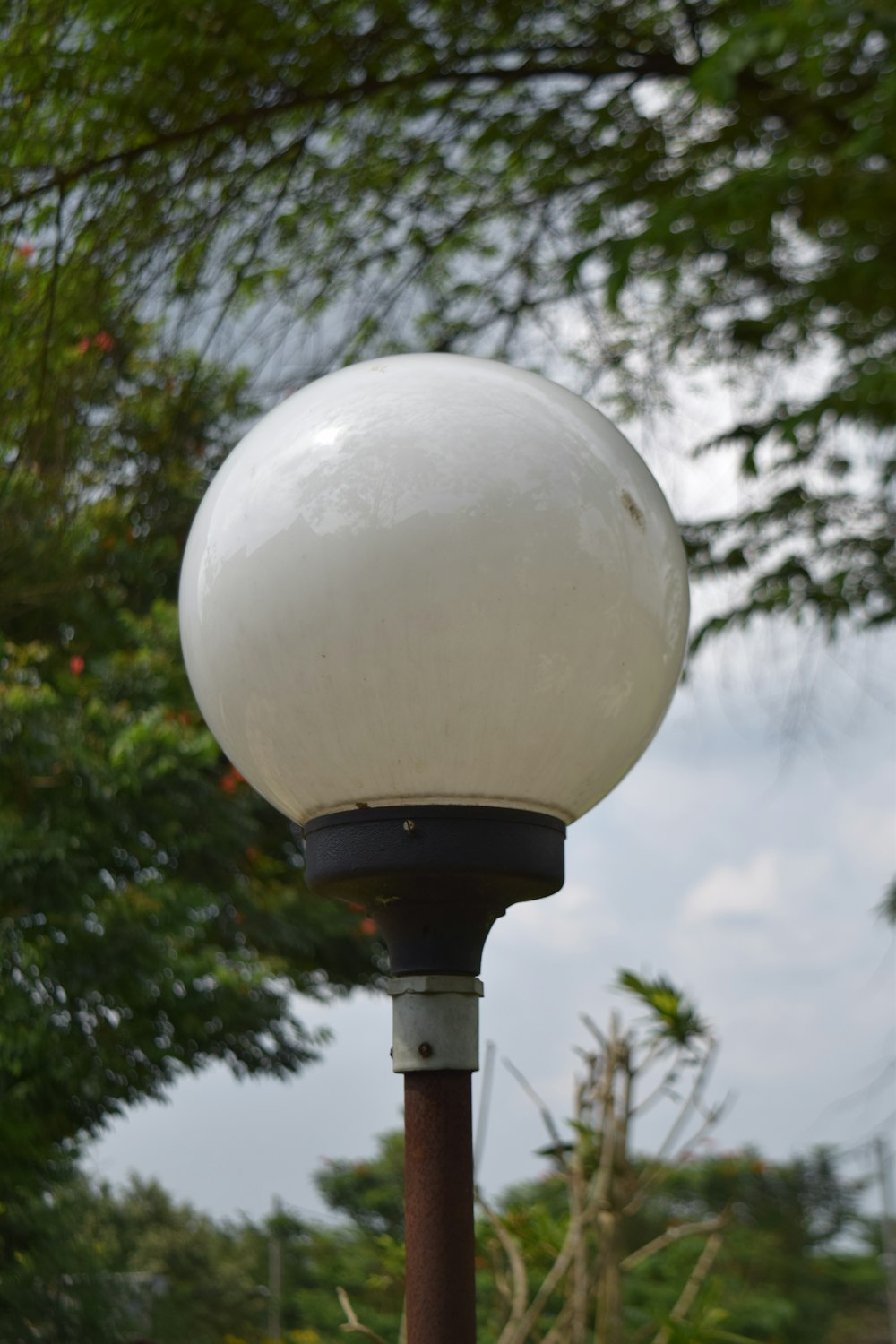 a street light with a white ball on top of it