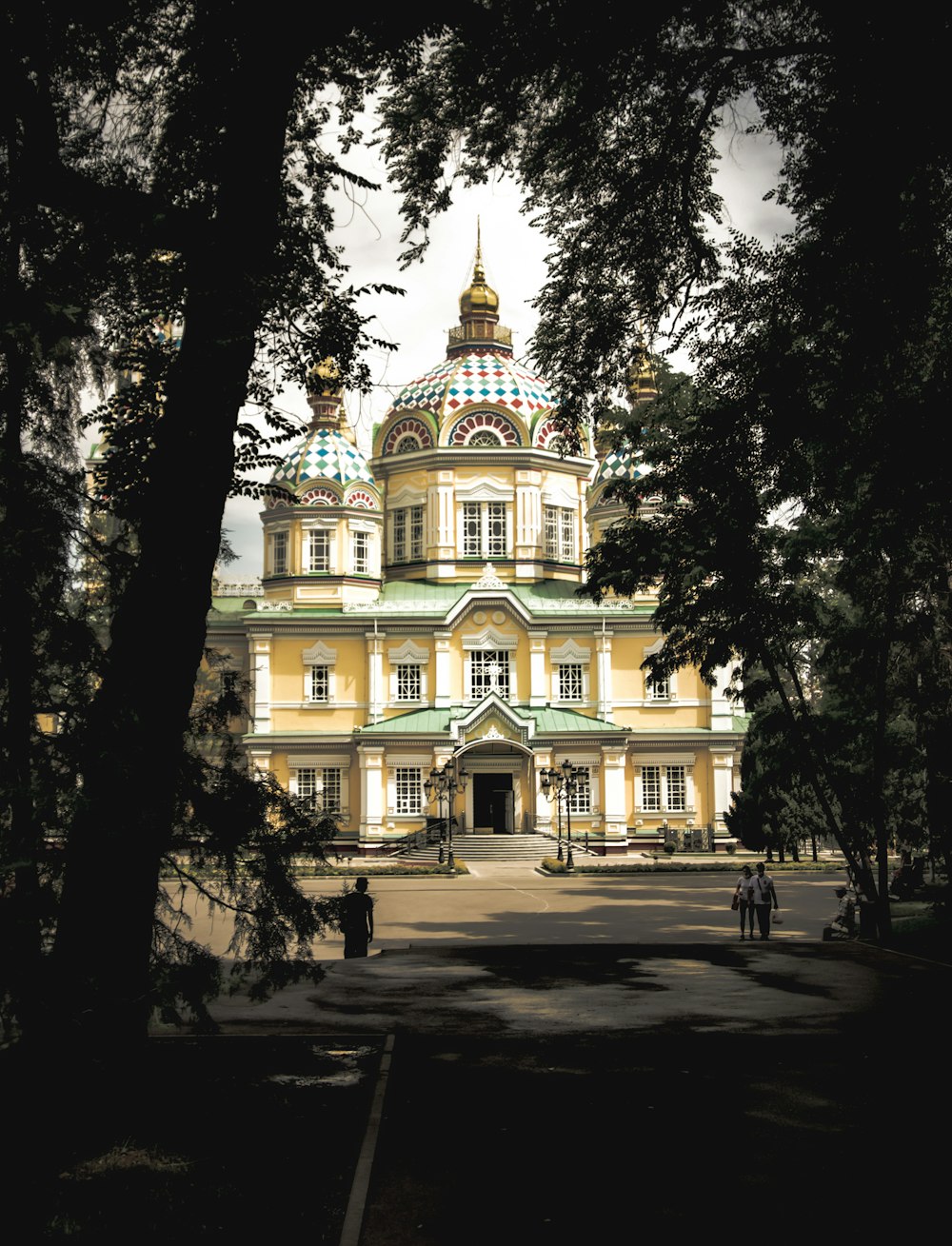 a large yellow building with a green roof