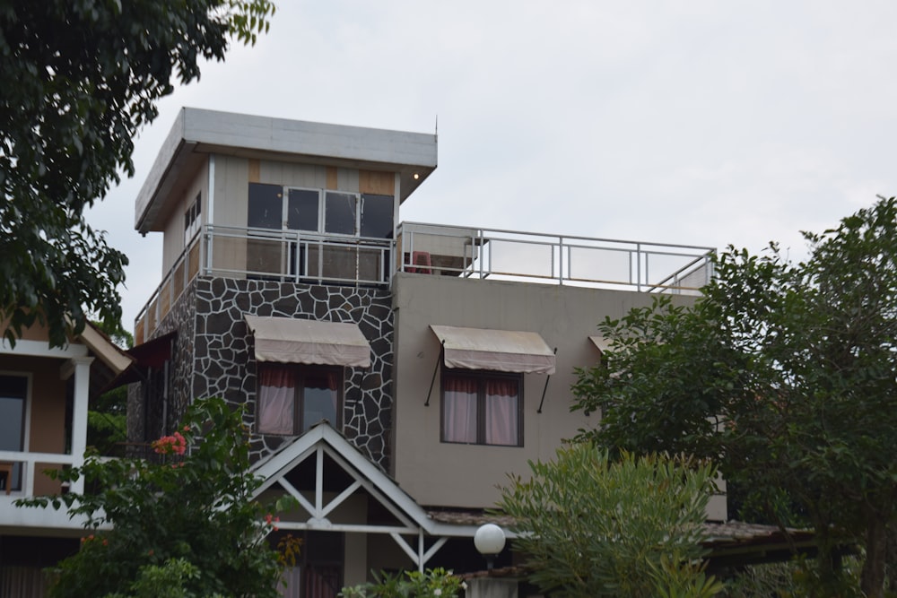 a house with a balcony and a balcony with curtains