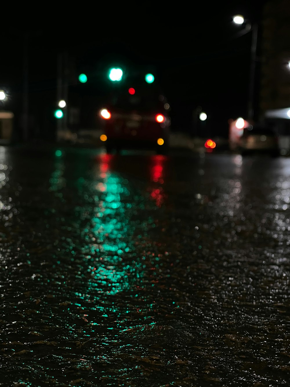a wet street at night with traffic lights