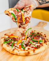 An inviting slice of pepperoni pizza being lifted, cheese stretching.