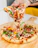 Close-up of a steaming hot pizza slice being lifted from a wooden board.