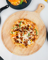 A colorful display of various pizzas and burgers on a wooden table.