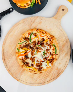 A colorful display of various pizzas and burgers on a wooden table.