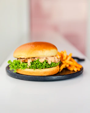 Juicy, stacked burger with fresh lettuce and a side of crispy fries.