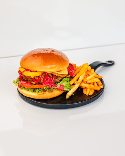 A vibrant burger with fresh ingredients and a side of fries.