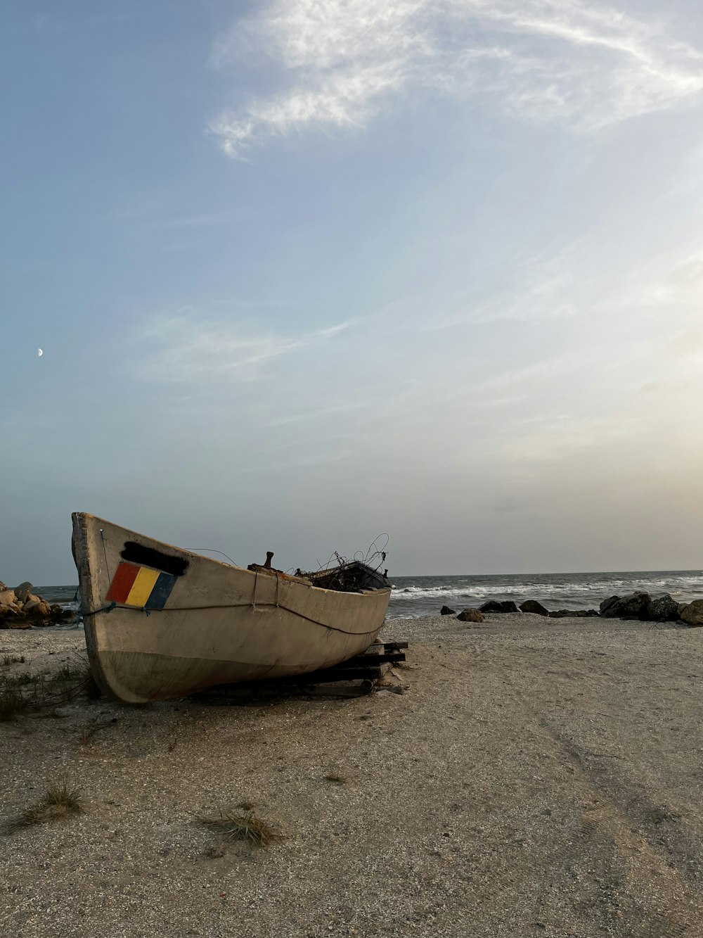 a boat sitting on top of a sandy beach