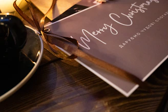 A close-up of luxurious gold-stamped Christmas cards, elegantly arranged on a festive wooden table.
