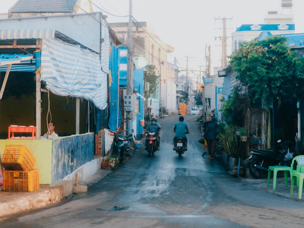 a couple of people riding motorcycles down a street