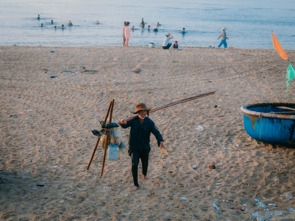 a person walking on a beach with a lot of people in the background