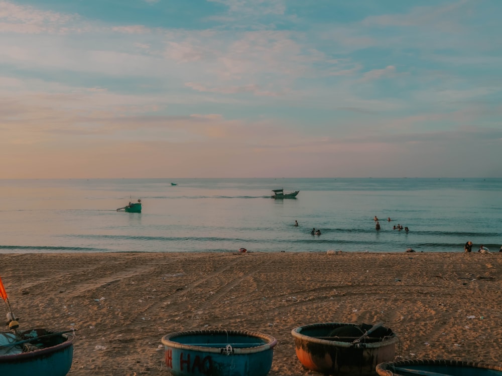 a group of buckets sitting on top of a sandy beach