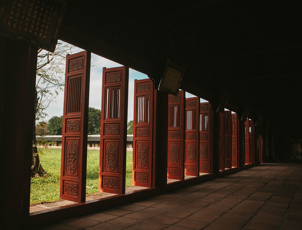 a row of red doors sitting next to a lush green field