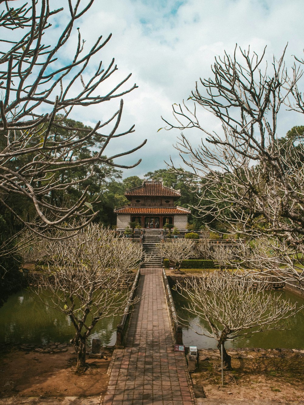 a walkway leading to a pavilion surrounded by trees