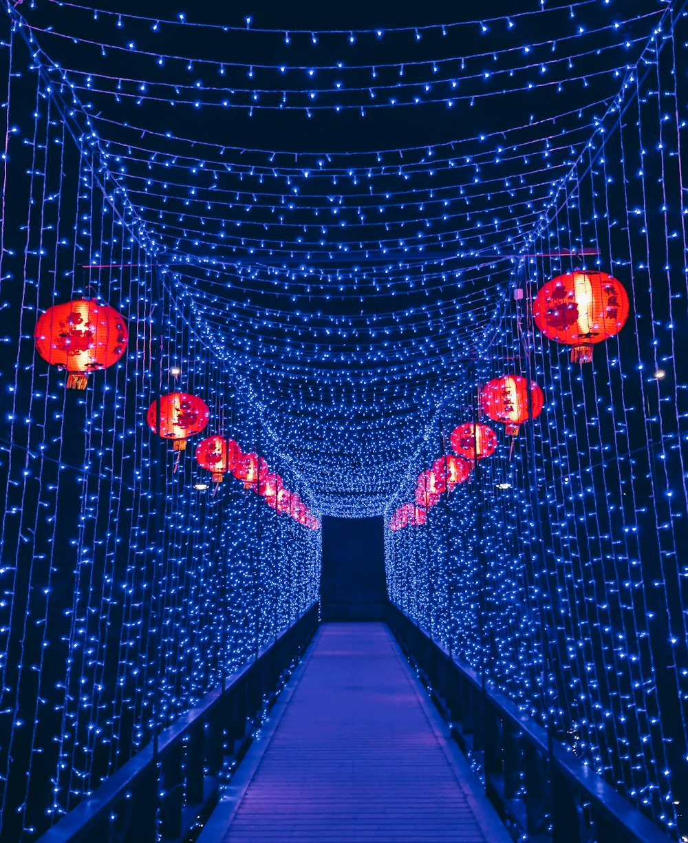 Un tunnel de lumières bleues avec des lanternes rouges