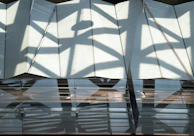 Abstract shadows play across a monochrome fabric draped elegantly over a geometric frame.