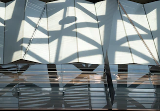 Abstract shadows play across a monochrome fabric draped elegantly over a geometric frame.