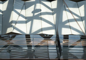 Close-up of architectural shadows and glassmorphism overlays highlighting premium materials and lighting.