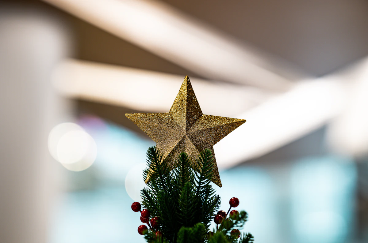 Gold star tree topper on a small Christmas tree