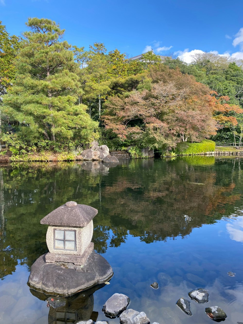 a small lantern sitting on top of a rock in the middle of a lake