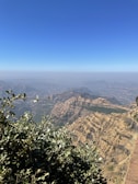 A panoramic view of the outback landscape with rugged hills and scattered shrubs stretching to the horizon.