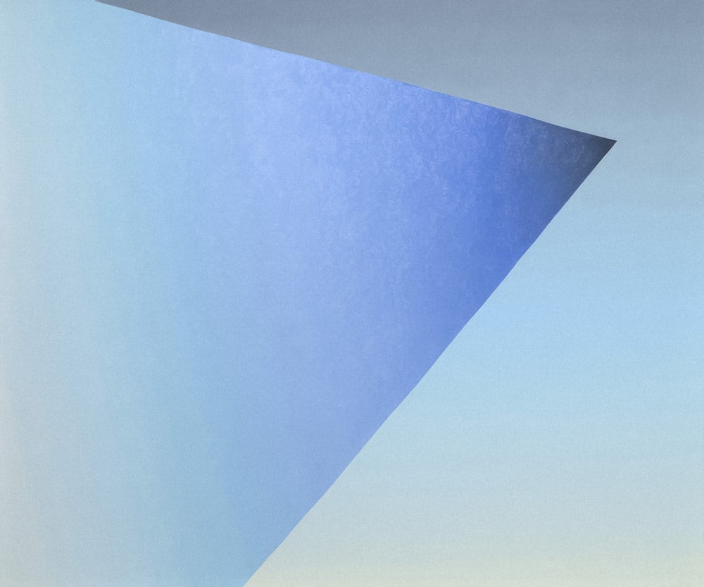 a painting of a blue triangle in the sky
