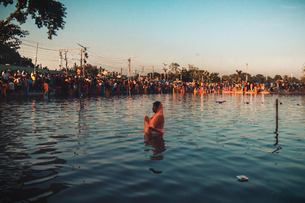 a crowd of people standing around a body of water