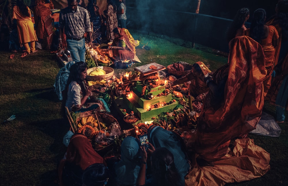 a group of people standing around a table covered in food