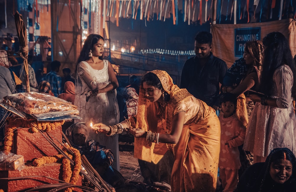 a group of people standing around a fire pit