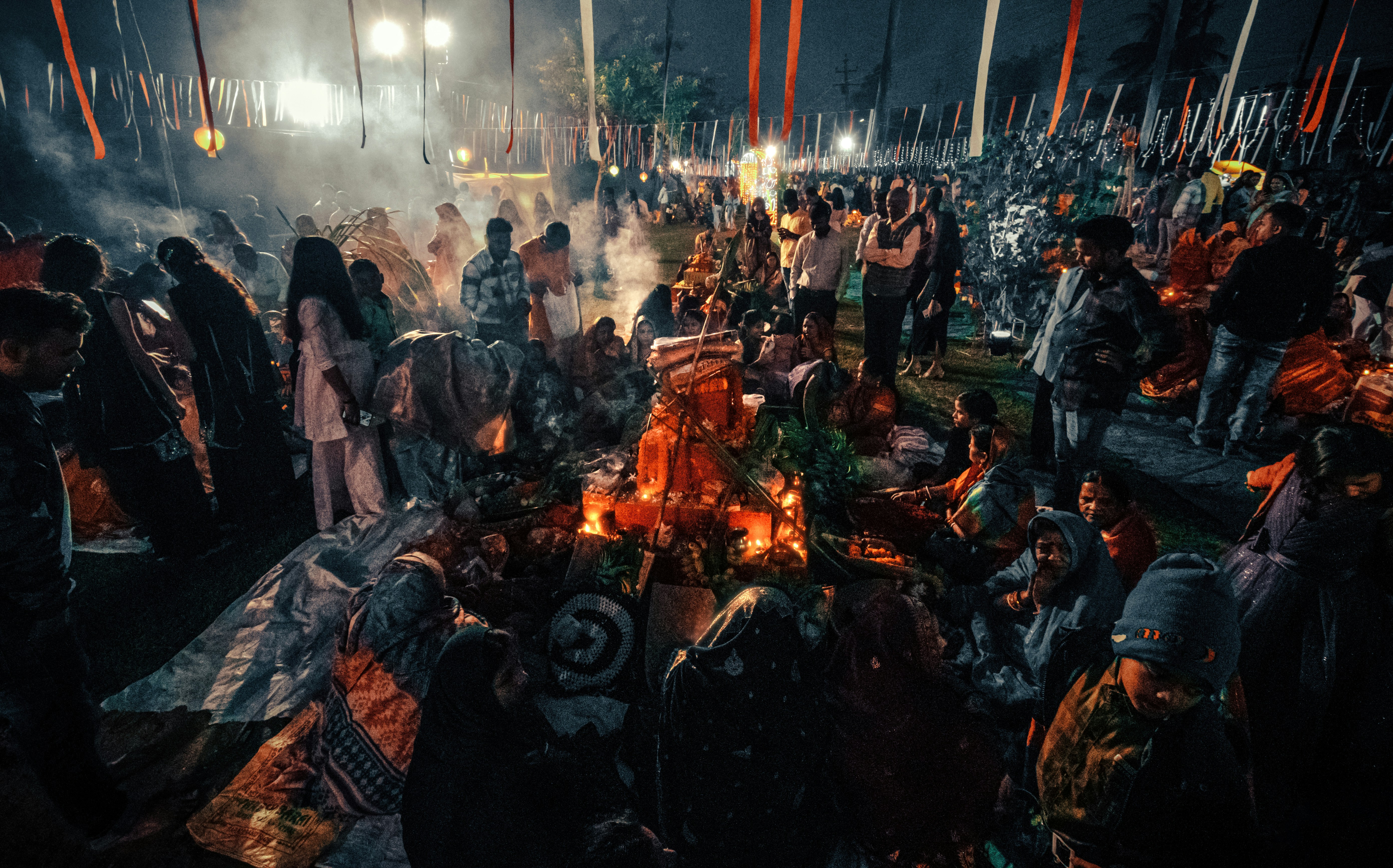 a group of people standing around a fire pit