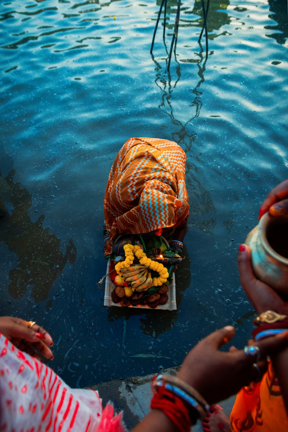 a group of people standing around a body of water