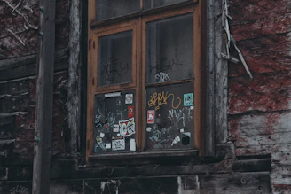 A rustic wooden window with peeling paint, telling a story of time.
