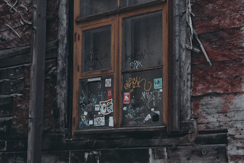 A rustic wooden window with peeling paint, telling a story of time.