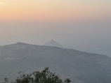 A misty mountain landscape fading into the horizon at dawn.