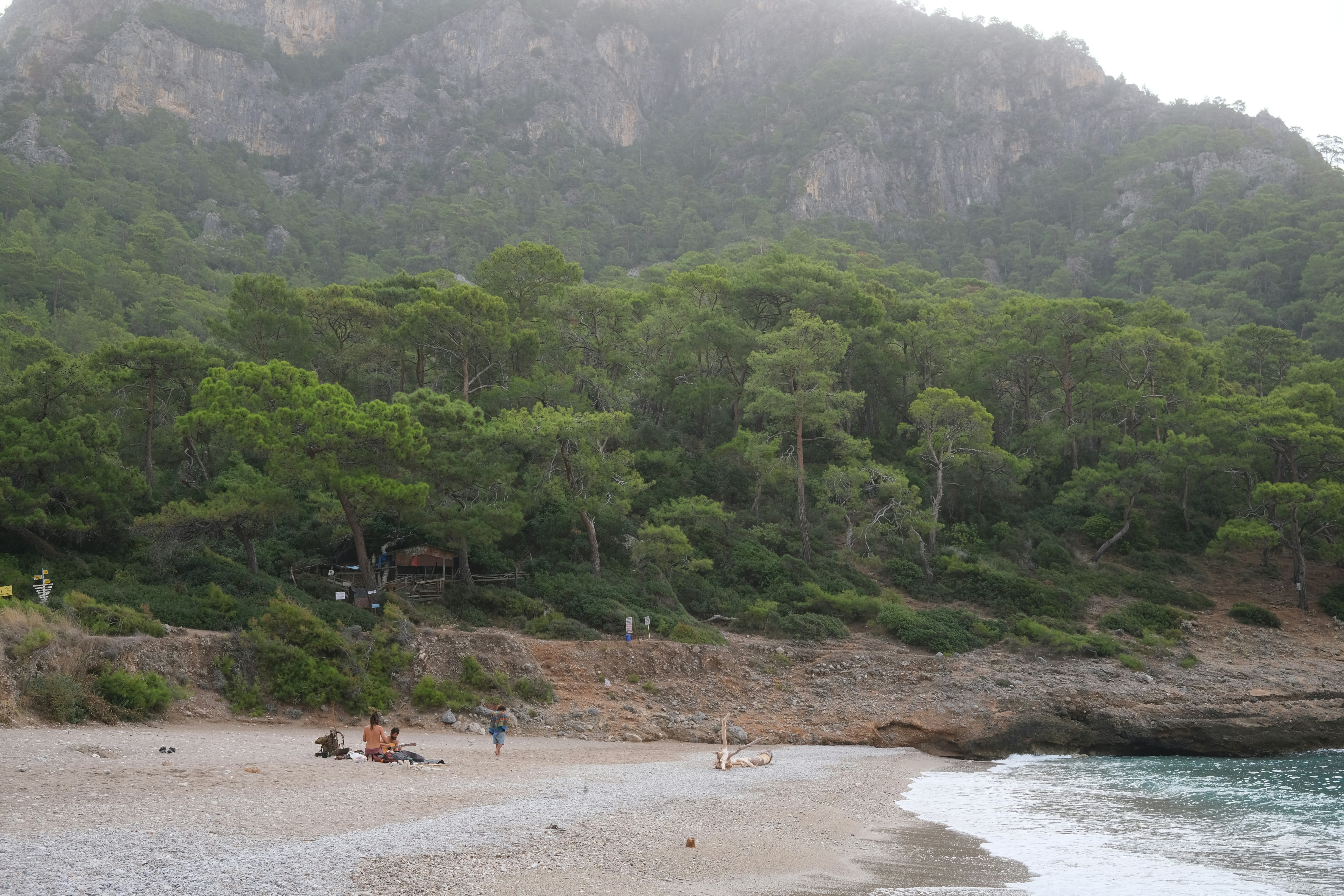 a group of people sitting on top of a sandy beach