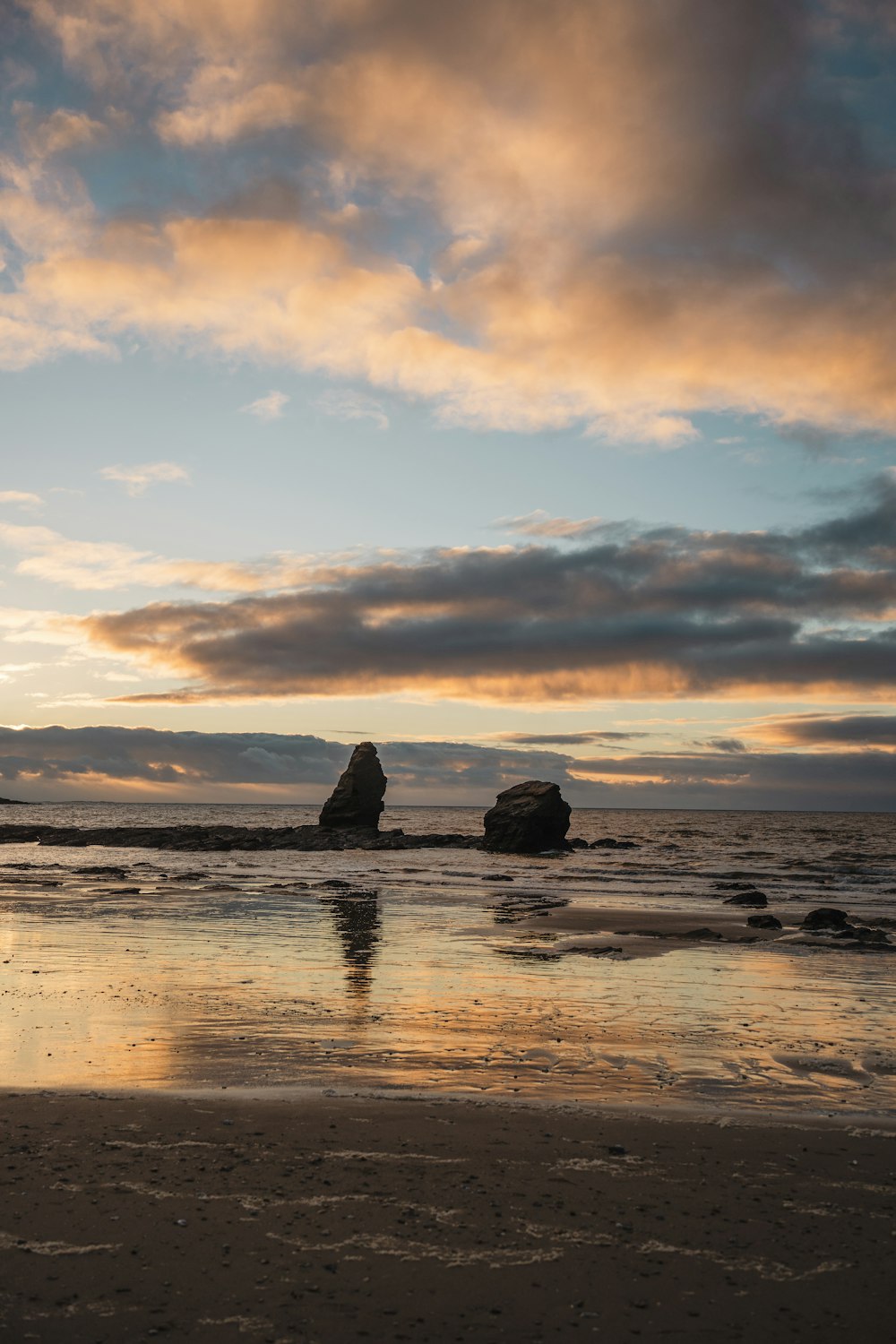 a couple of large rocks sitting on top of a beach